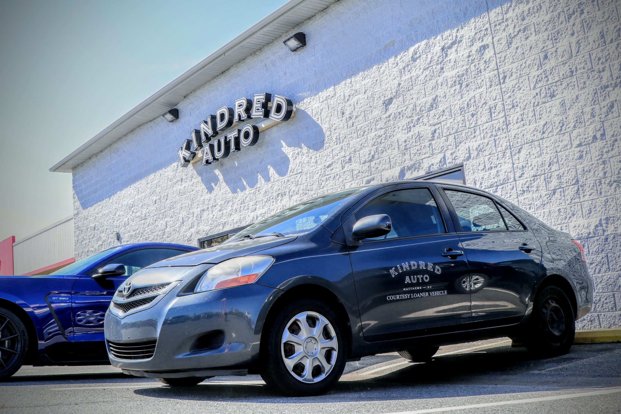 Kindred Loaner Car Parked In Front Of Automotive Repair Shop